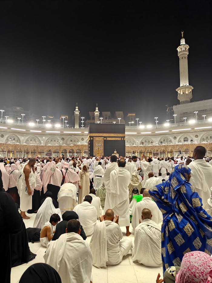 Thousands gather for prayers at the Kaaba in Mecca during nighttime pilgrimage.
